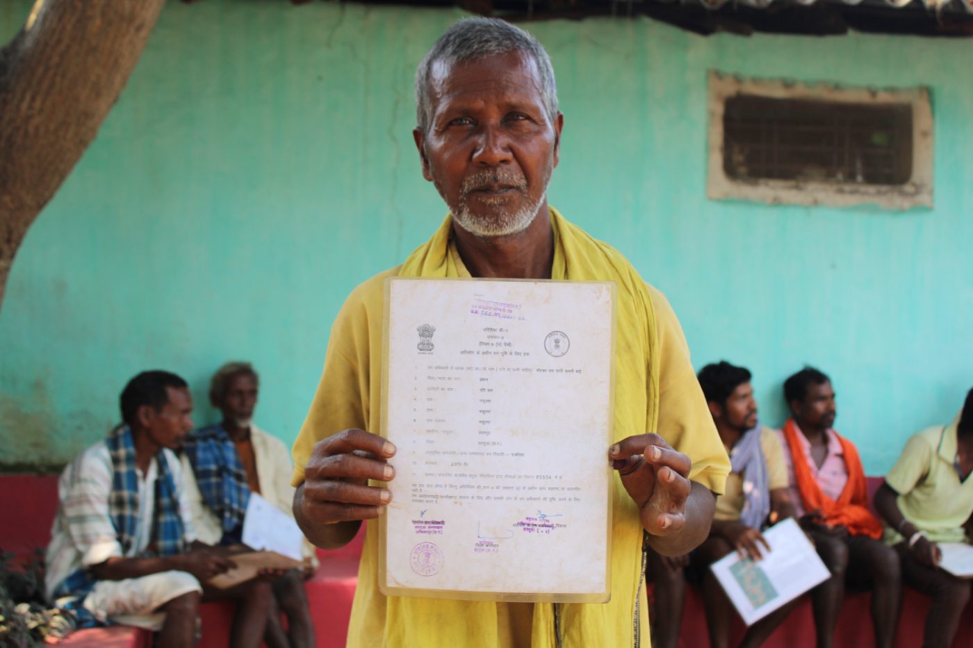 A Pahadi Korwa elder in Chhattisgarh holds up his forest rights title