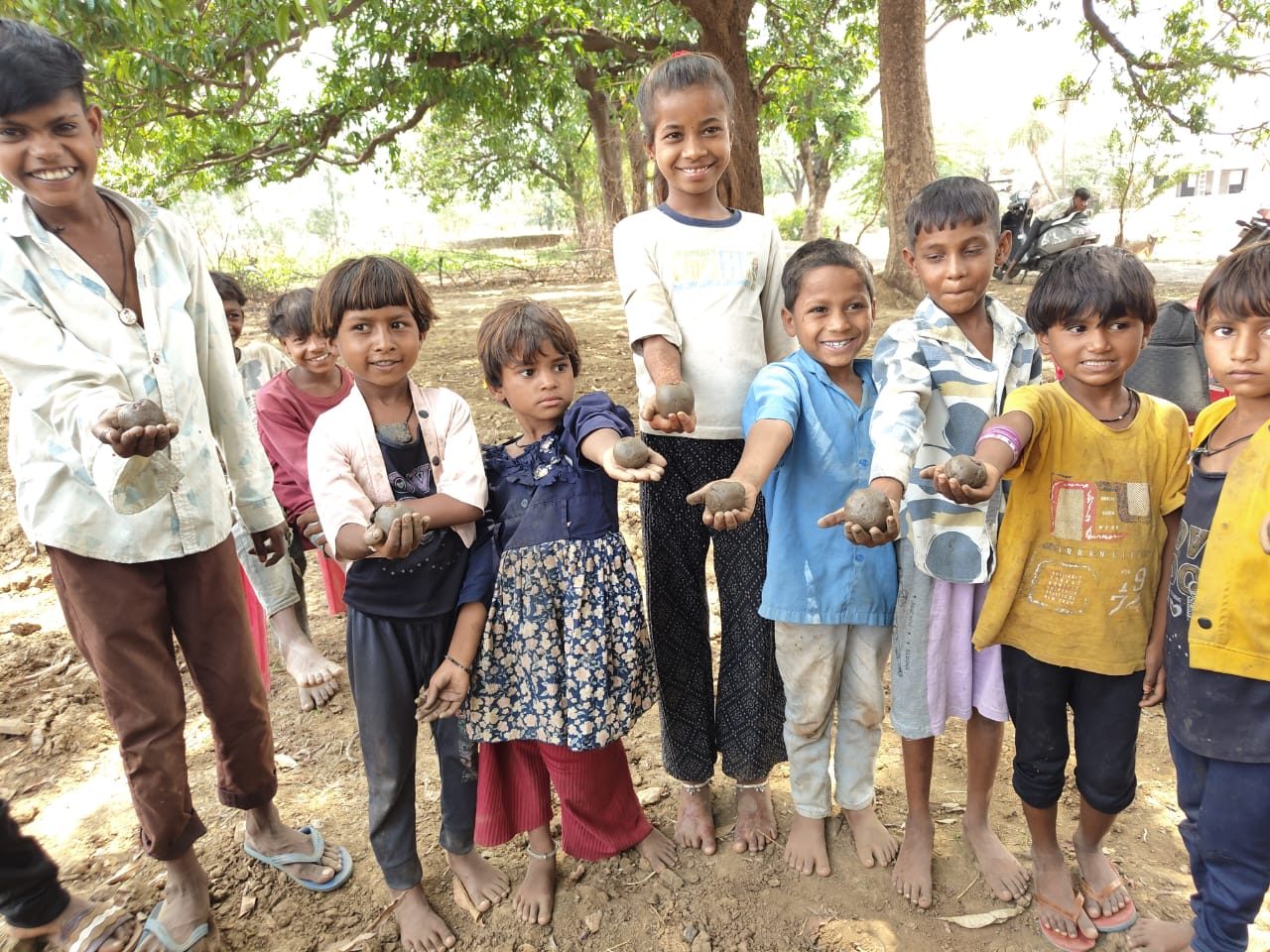 Children in Banswara holding out seed balls at a seed festival